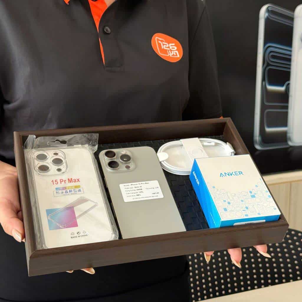 Nhân viên 126.vn giao iPhone 15 Pro Max cũ cho khách kèm hộp và phụ kiện tại cửa hàng Vĩnh Long