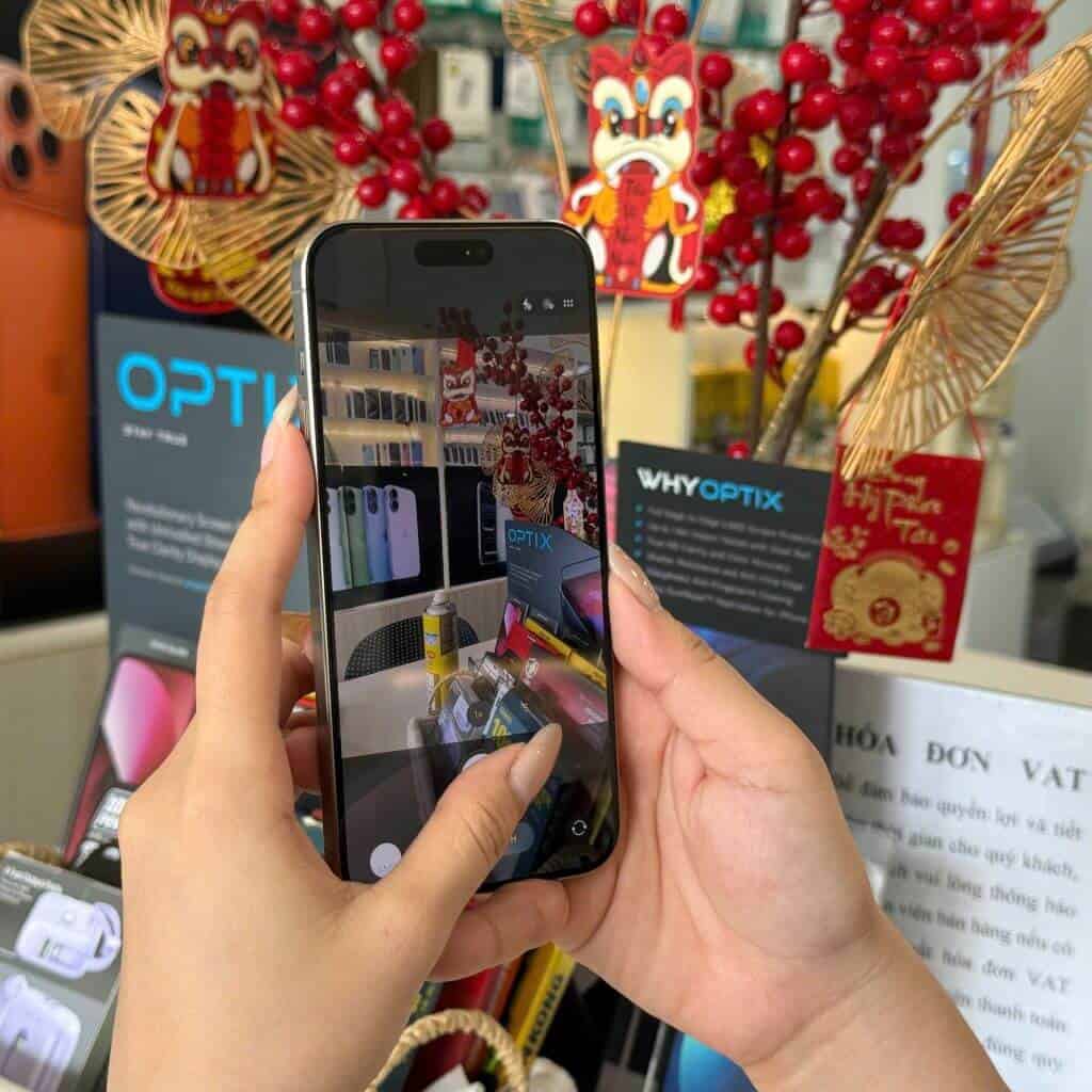 Khách hàng đang kiểm tra iPhone 15 Pro Max cũ tại cửa hàng 126.vn Vĩnh Long