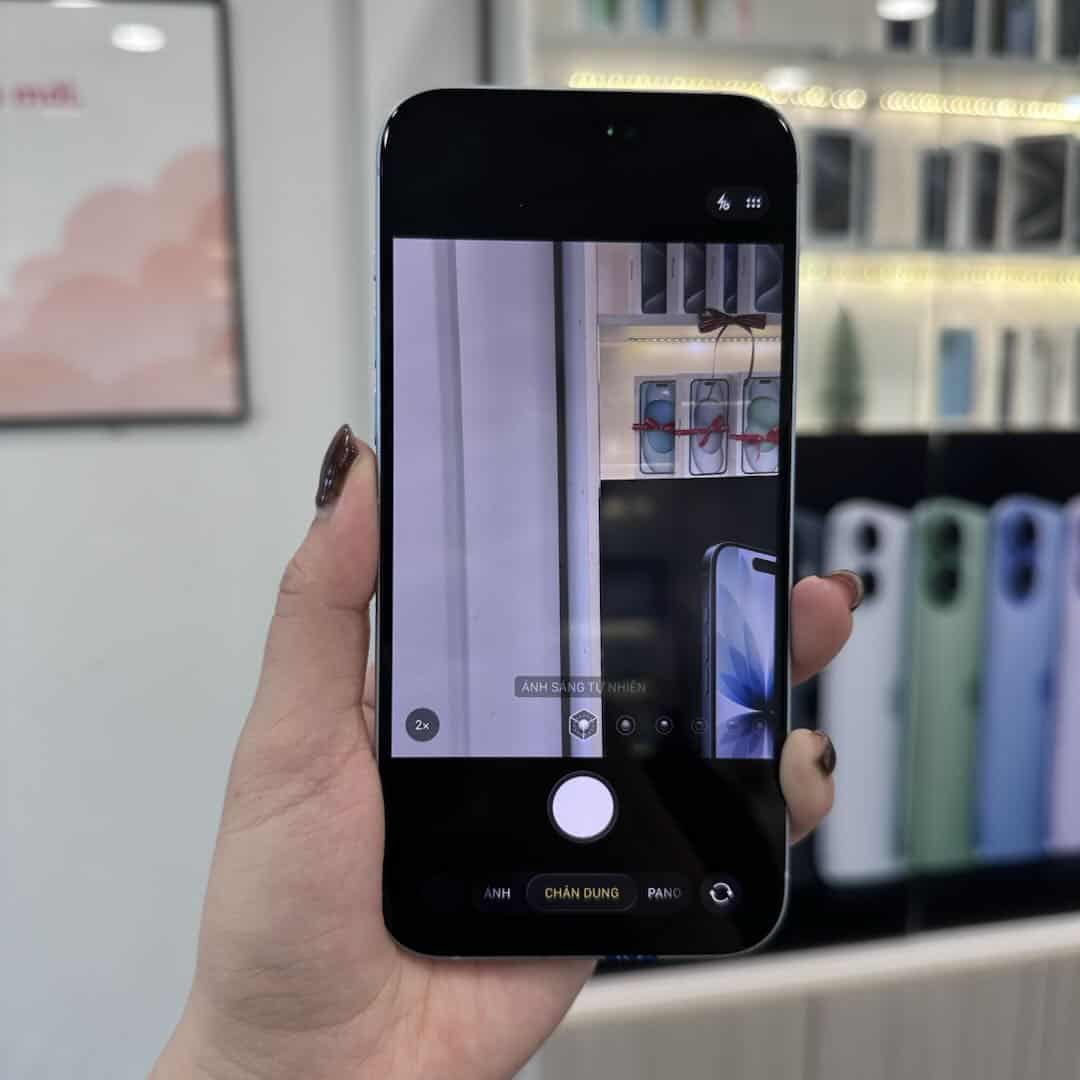 Nhân viên 126.vn mở ứng dụng Camera kiểm tra iPhone 15 Plus cũ tại cửa hàng