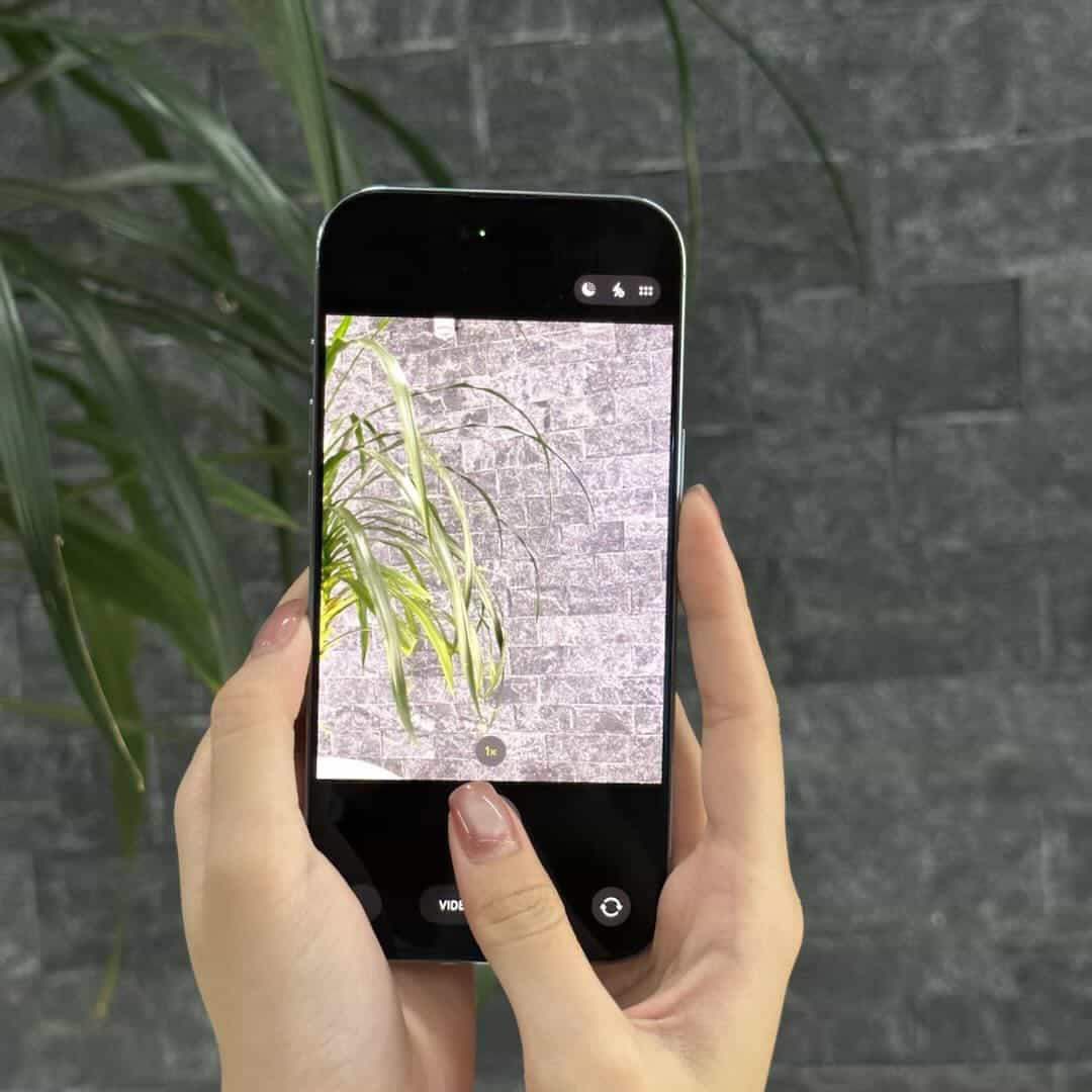 Khách cầm hai tay chụp thử camera iPhone Air cũ tại 126.vn