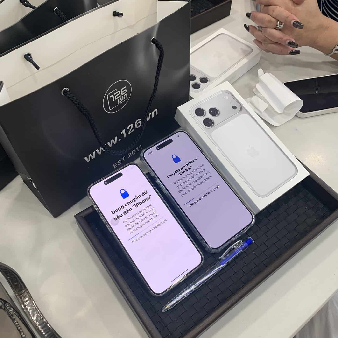 Nhân viên 126.vn chuyển dữ liệu từ máy cũ sang iPhone mới cho khách tại cửa hàng Vĩnh Long