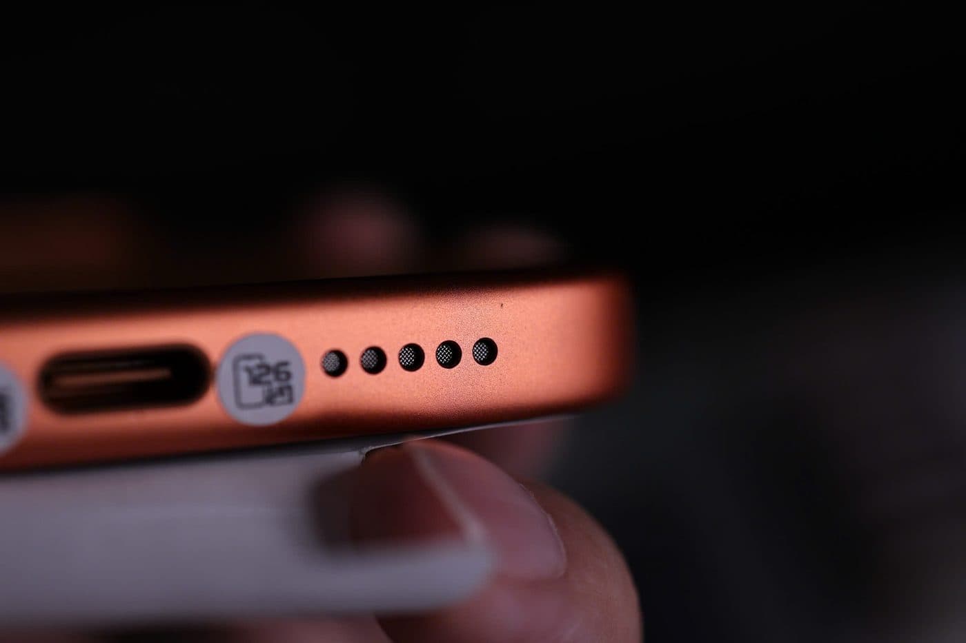 Cận cảnh lỗ loa và mic ở cạnh dưới một chiếc iPhone khi kiểm máy